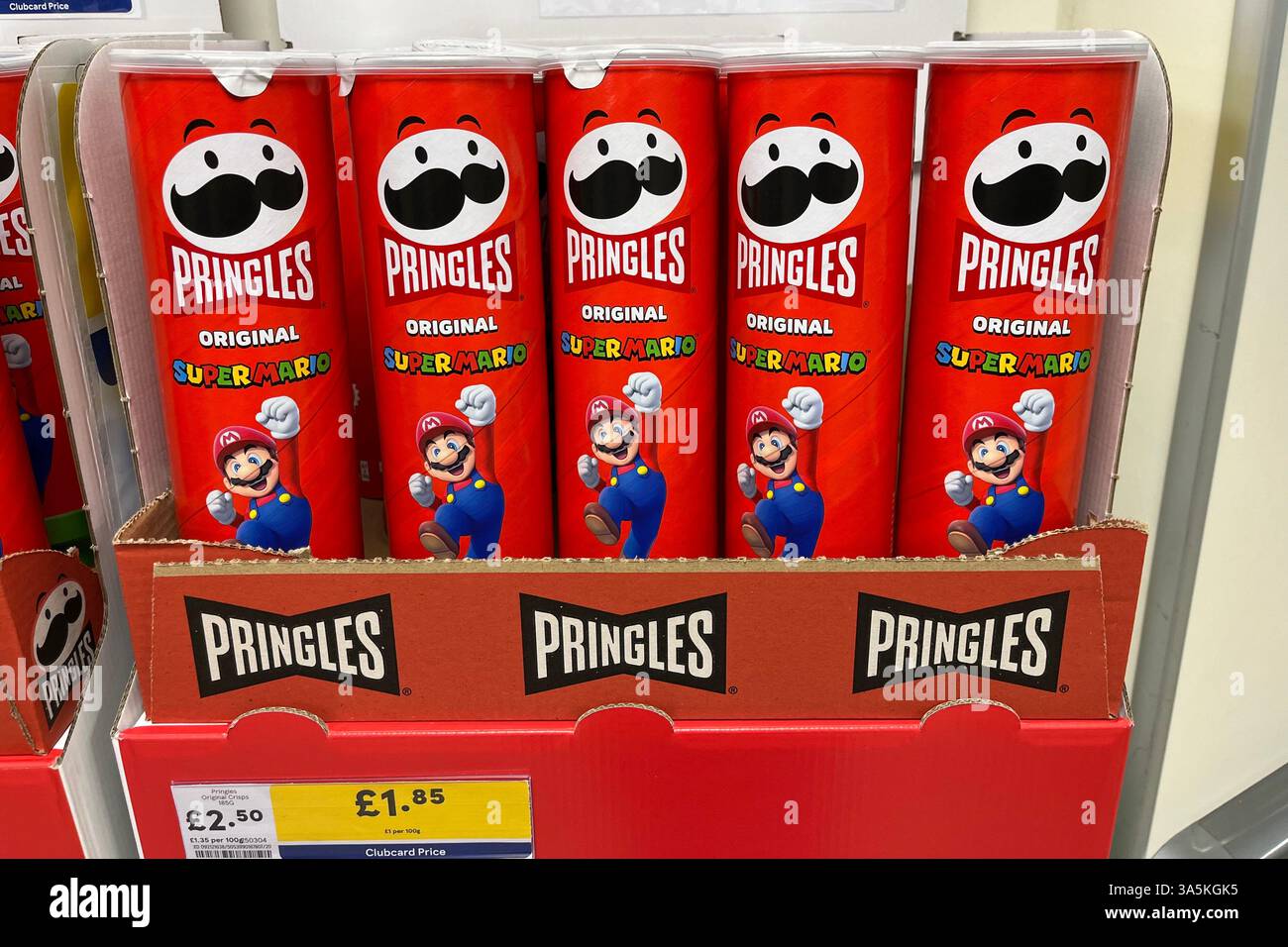 Eine Linie von Pringles Original Röhren mit Super Mario Werbelogo in einem Tesco Supermarkt. Februar 2025. - Smartphone-aufgenommenes Stockfoto