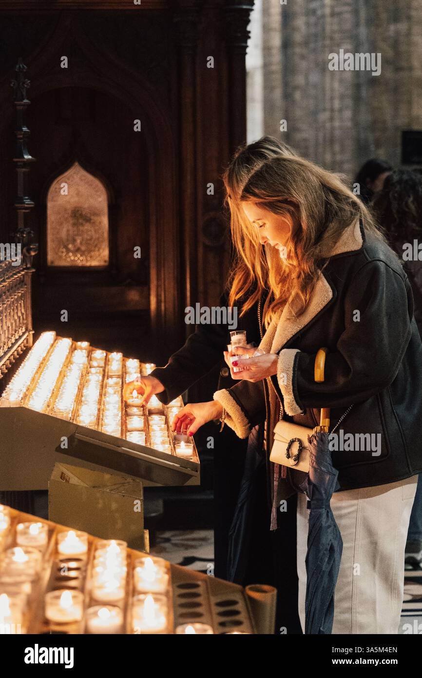 Frauen zünden Votivkerzen in der Mailänder Kathedrale, Mailand, Italien Stockfoto