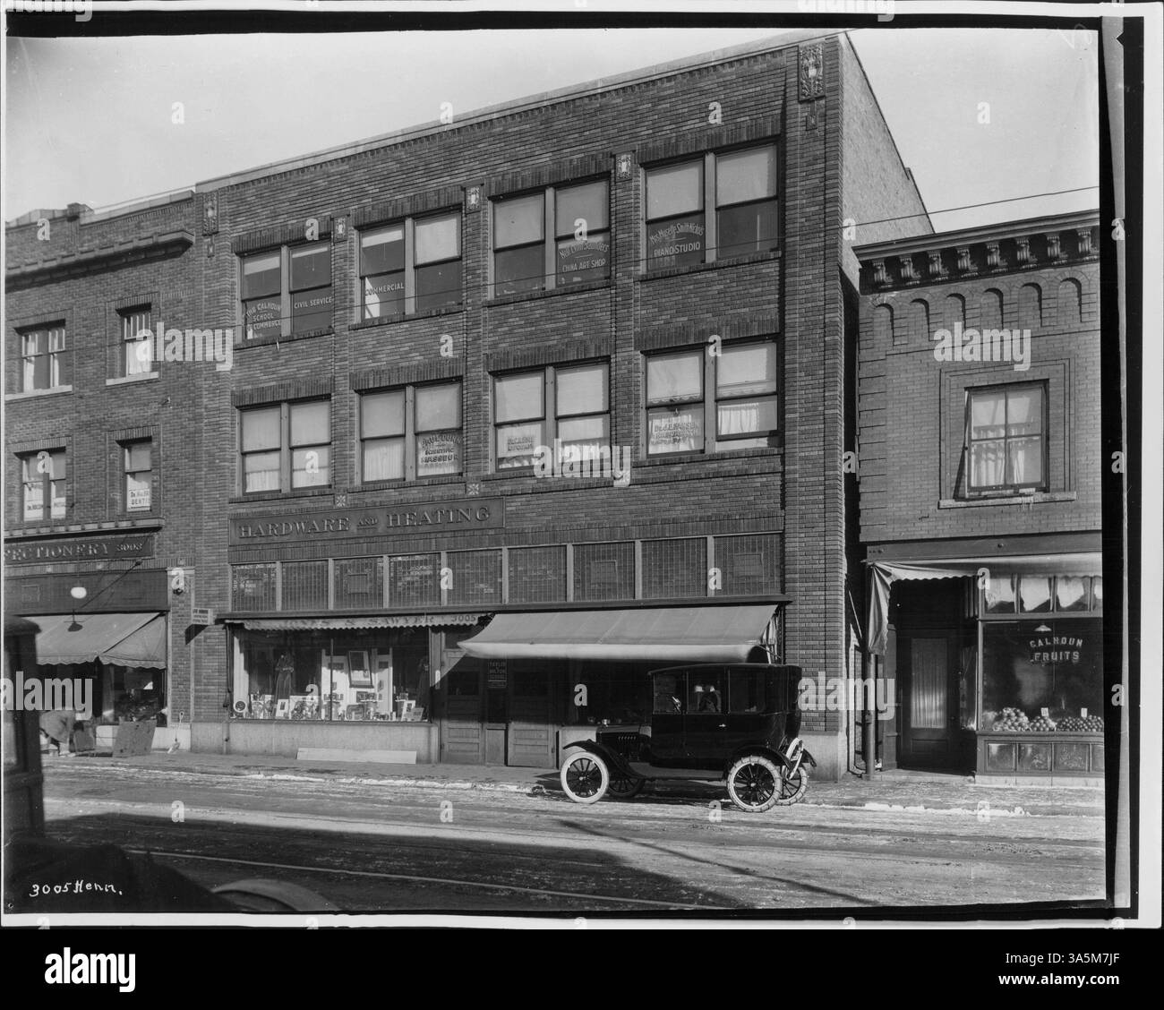 Ein Foto, das Unternehmen entlang der Hennepin Avenue zeigt, mit einem Arbeiter ganz links, der ein Gespräch führt, und einem Auto mit Reifenketten. Stockfoto