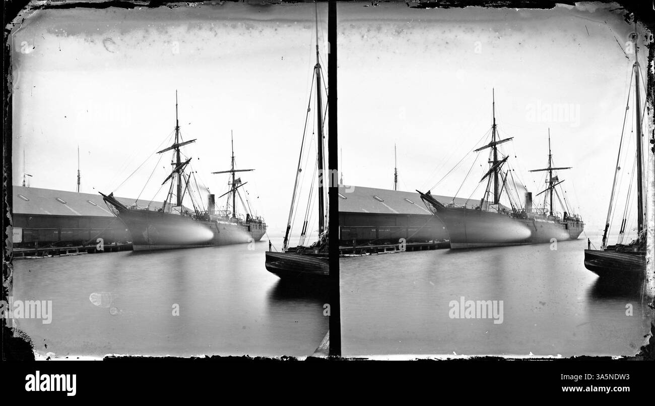 Dieses Foto zeigt einen Lake Superior Tour Dampfer, der an einem Hafen angedockt ist, mit Boston und Albany Railroad Wagen auf nahe gelegenen Gleisen, die die Verkehrsverbindungen und die malerische Aussicht auf Lake Superior hervorheben. Stockfoto
