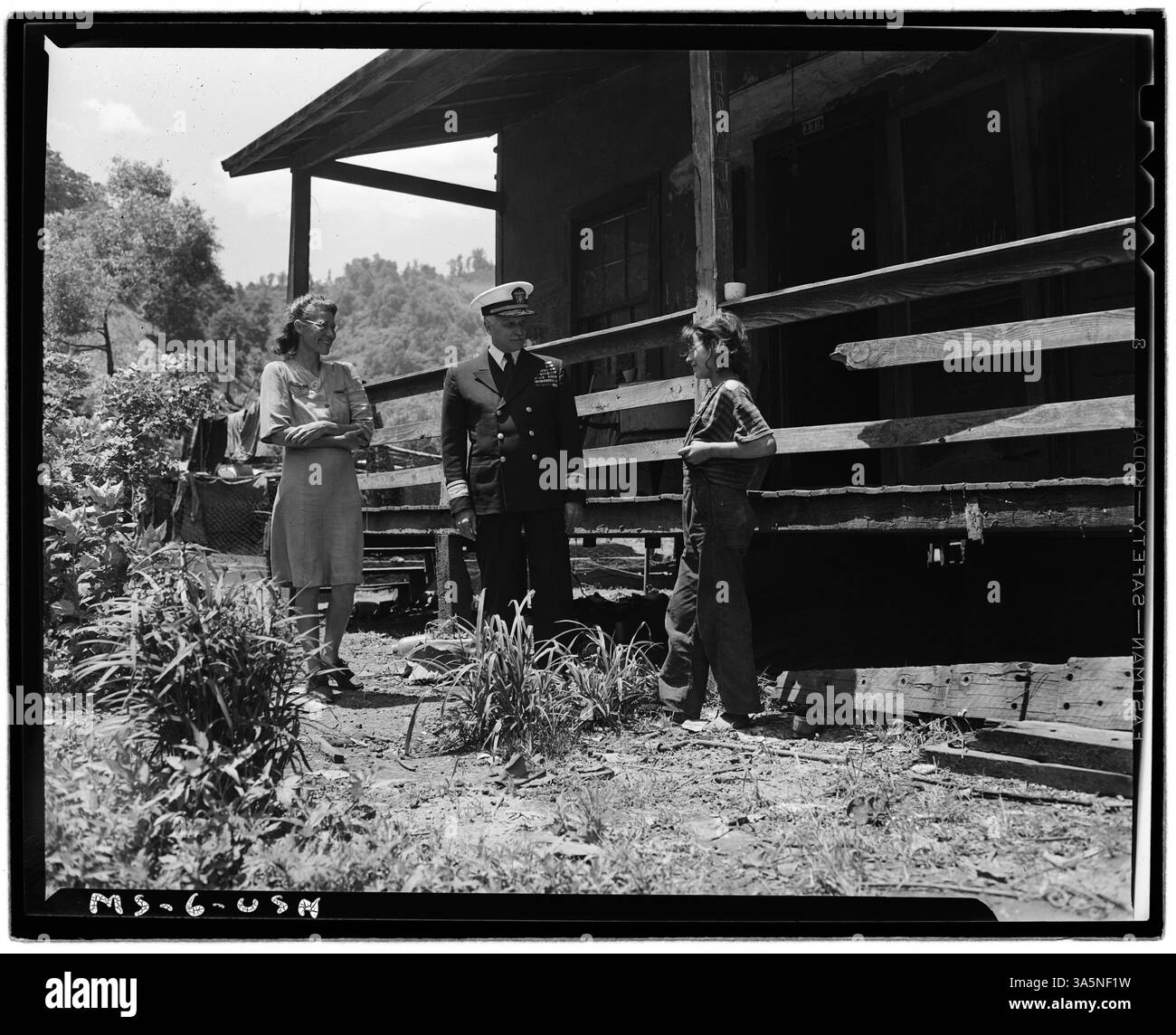 Mrs. B. Blankenship, die Frau eines Bergarbeiters, und ihre Tochter sprechen mit Admiral Joel T. Boone vor ihrem Haus in Weeksbury, Floyd County, Kentucky. Das Bild spiegelt die persönlichen Verbindungen innerhalb der Bergbaugemeinden wider. Stockfoto
