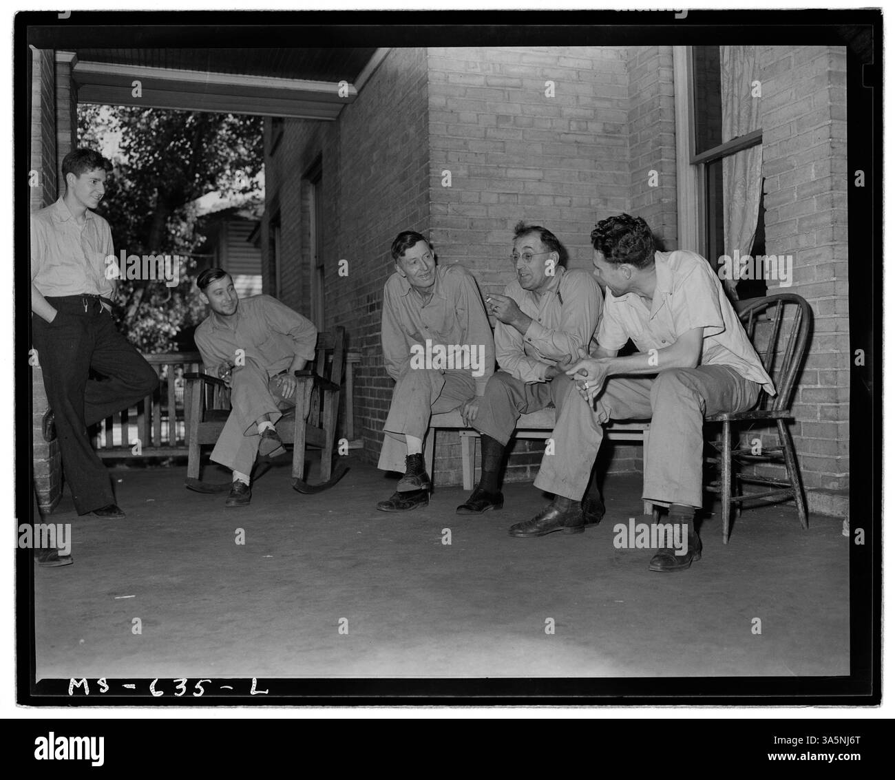 Bergleute, die in einem Hotel in der Castle Gate Mine der Utah Fuel Company in Carbon County, Utah, wohnen, unterhalten sich auf der Veranda und veranschaulichen den sozialen Aspekt des Lebens in Bergbaustädten. Stockfoto