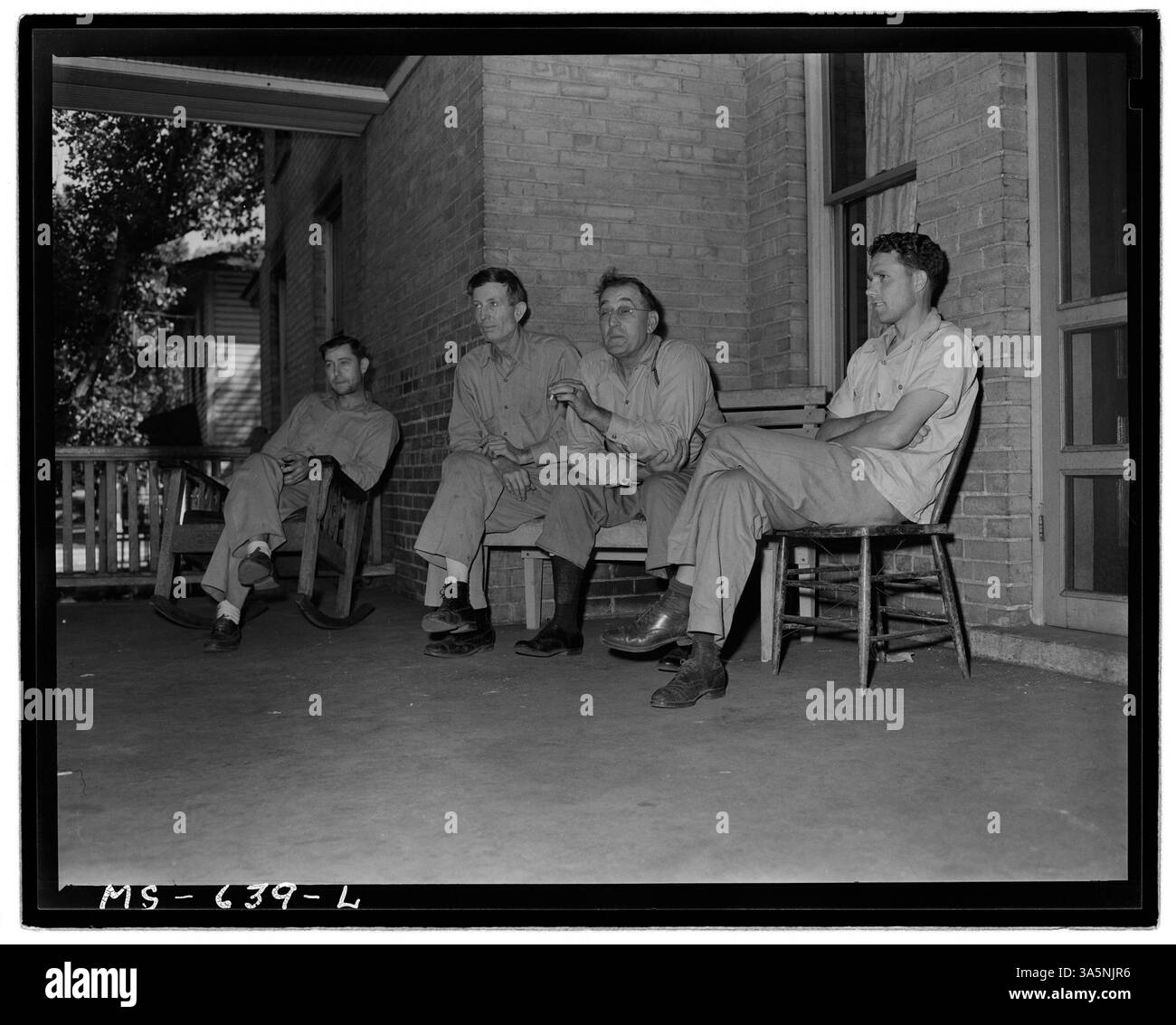 Bergleute, die in einem Hotel in der Castle Gate Mine der Utah Fuel Company in Castle Gate, Carbon County, Utah, leben, werden während ihrer Freizeit auf der Veranda beobachtet, wie sie sich unterhalten. Stockfoto