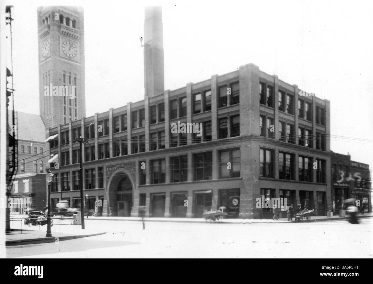 Das Mehl Exchange Building an der Kreuzung von 3rd Street und 4th Avenue South, ursprünglich vier Stockwerke hoch, wurde 1909 um sieben weitere Stockwerke erweitert. Ein Mann mit einem Gemüsewagen ist an der Ecke zu sehen, mit einem sehr frühen Auto links in diesem historischen Bild. Stockfoto