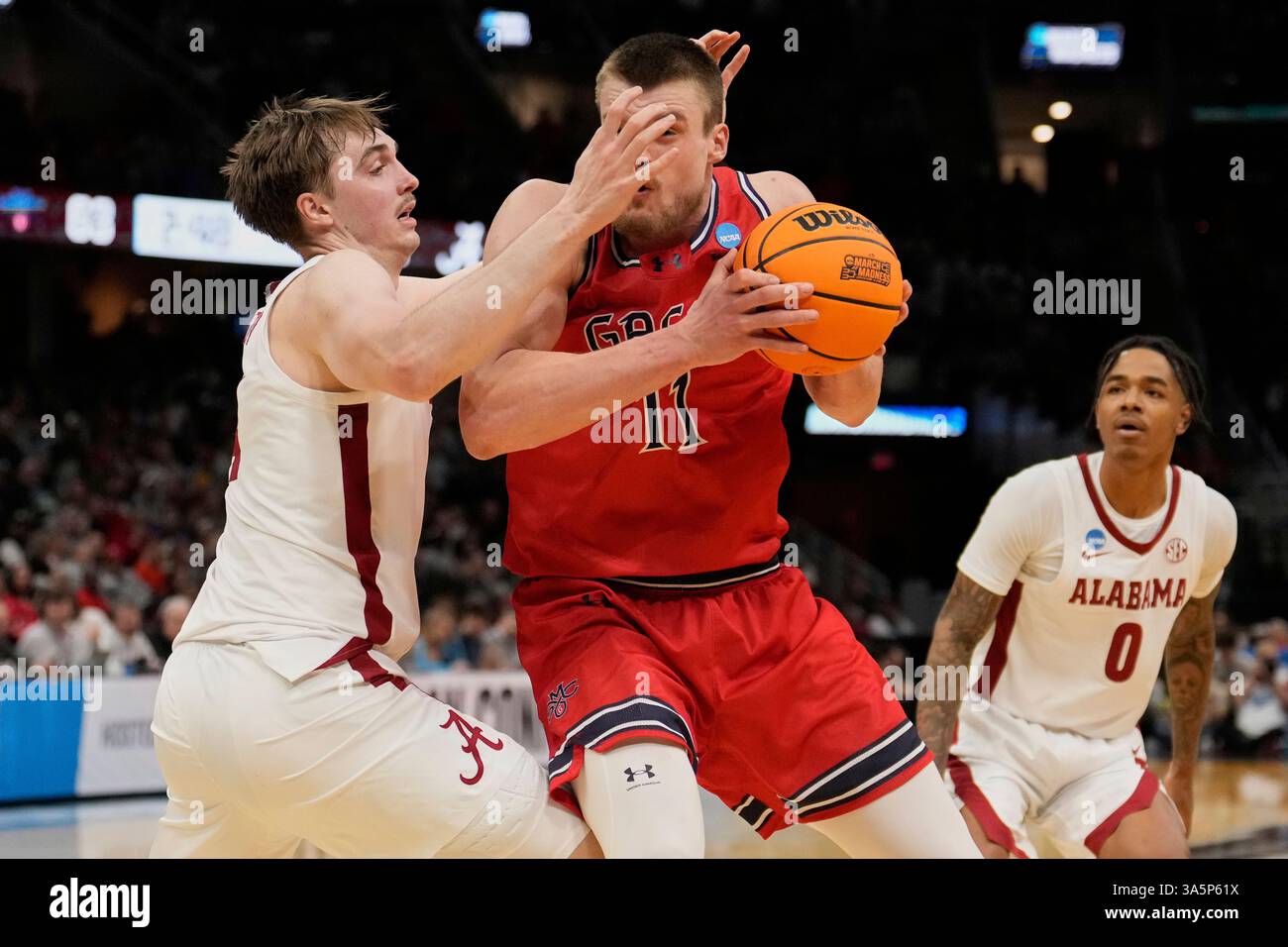 Alabama forward Grant Nelson, left, defends Saint Mary's center Mitchell Saxen (11) in the second half in the second round of the NCAA college basketball tournament, Sunday, March 23, 2025, in Cleveland. (AP Photo/Sue Ogrocki) Stockfoto