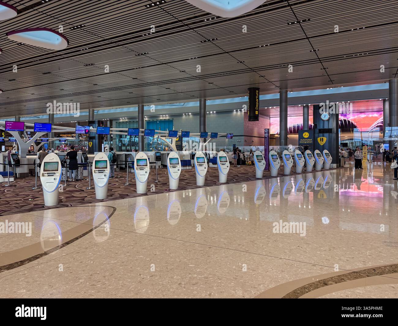 Changi International Airport mit Reihen von weißen automatischen Check-in-Automaten für Abflüge auf einem glänzend sauberen Boden. Stockfoto