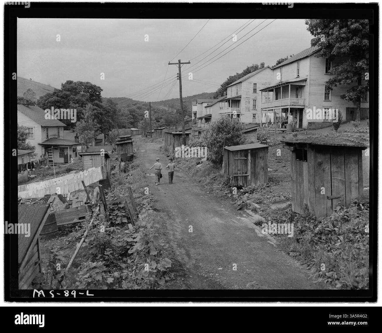 Privilegien, die sich entlang einer Gasse in einem Firmenwohnungsprojekt für Bergleute in der Koppers Coal Division, Federal #1 Mine in Grant Town, West Virginia, erstrecken, spiegeln die grundlegenden Lebensbedingungen der damaligen Zeit wider. Stockfoto