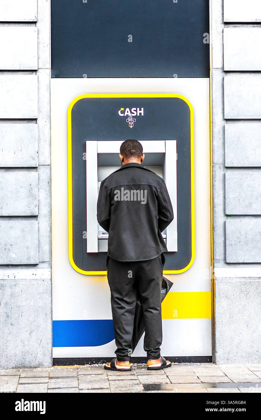 Mann an einem Geldautomaten in Brüssel, Belgien. Stockfoto