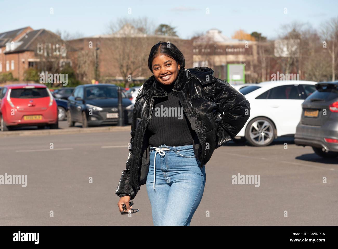 Chichester England Großbritannien. 18.03.2025. Frau in schwarzer Jacke und trägt Jeans. Stockfoto