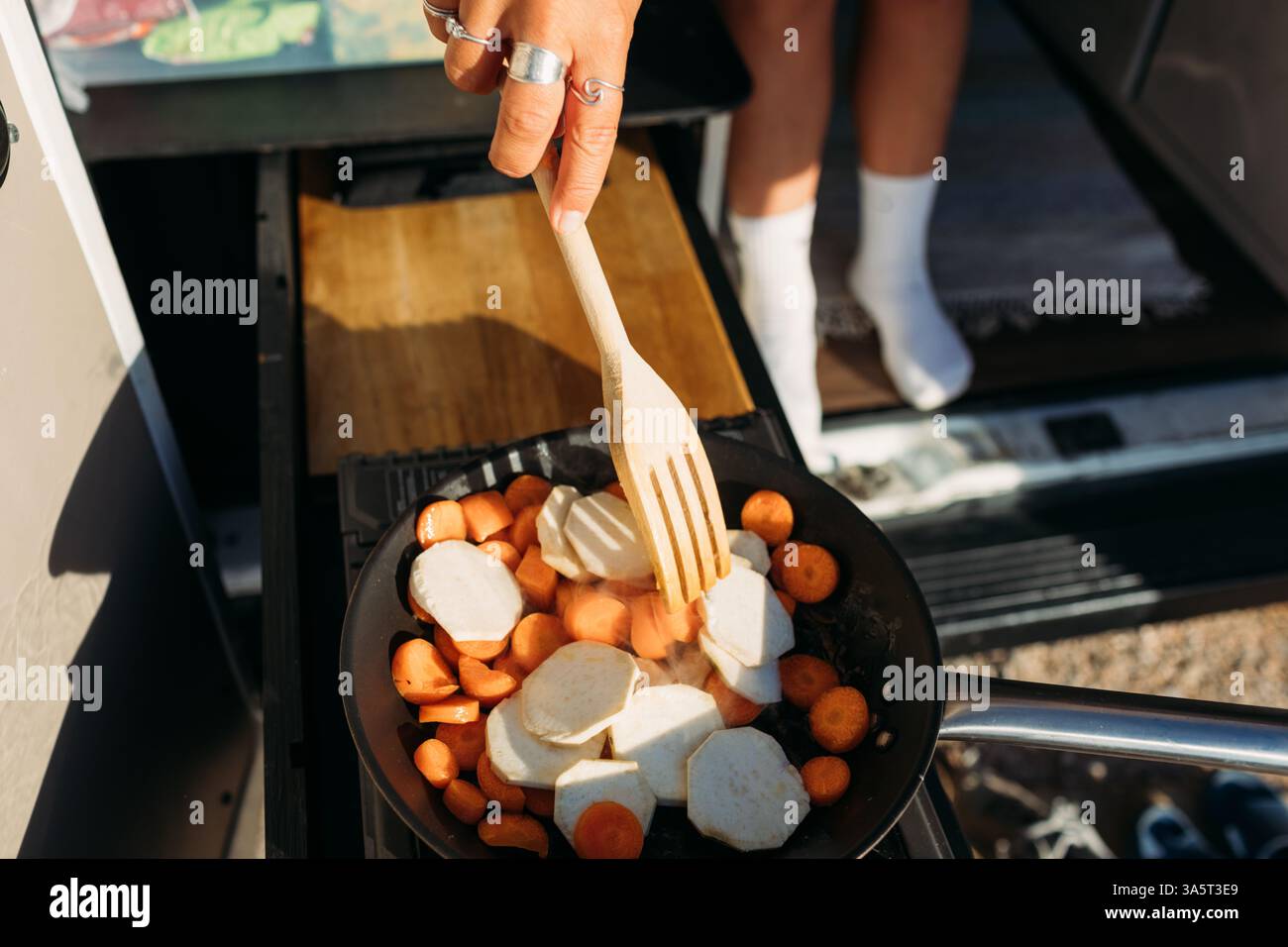 Kochen Sie frische Karotten und Süßkartoffeln in einer Van-Küche Stockfoto