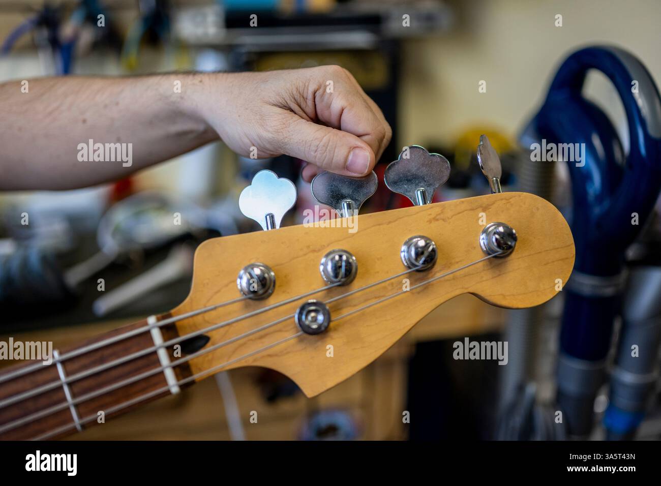 Der Typ stimmt Gitarre im Laden Stockfoto