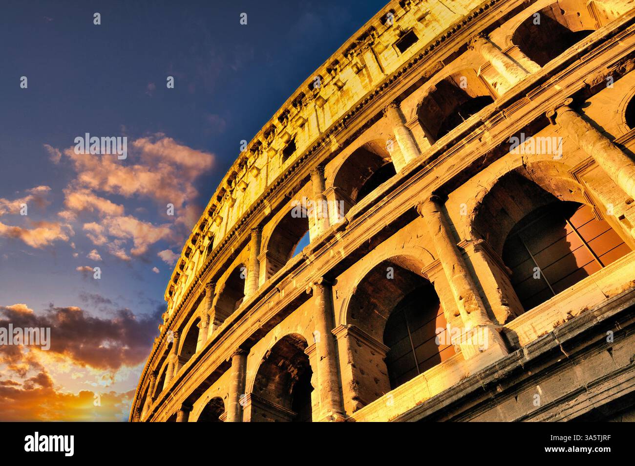 Das Kolosseum in Rom steht hoch unter einem lebhaften Sonnenuntergang, mit Wolken in warmen Farbtönen. Rom. Italien Stockfoto