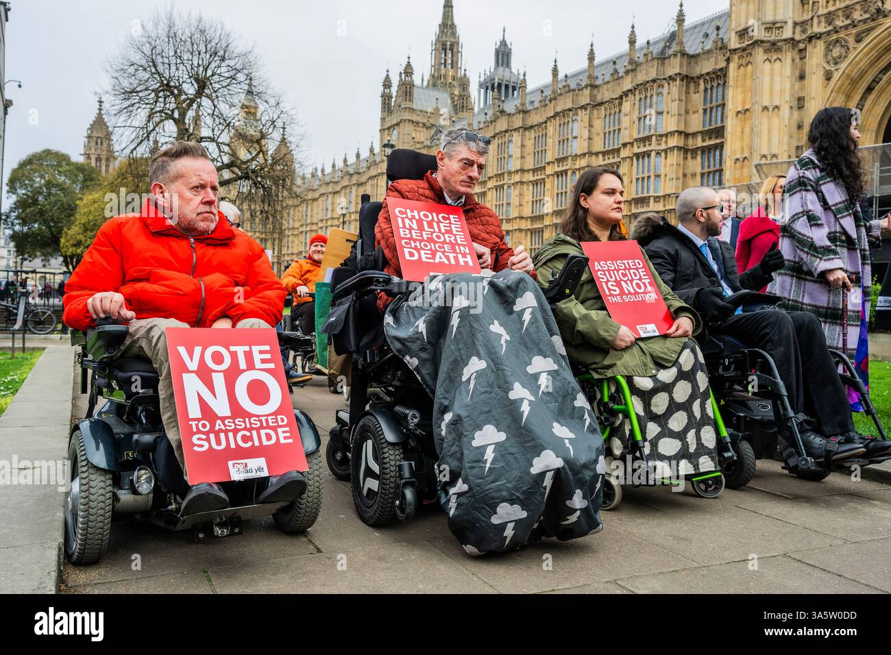 London, Großbritannien. März 2025. Behinderte Gegner (mit Plakaten, auf denen steht, dass Assisted Suicide nicht die Antwort ist, und sie sind "noch nicht tot") des britischen Sterbegesetzes kommen nach Westminster und treffen sich auf College Green vor dem parlament, um zu protestieren, während das Gesetz seine Ausschussphase durchläuft. Guy Bell/Alamy Live News Stockfoto