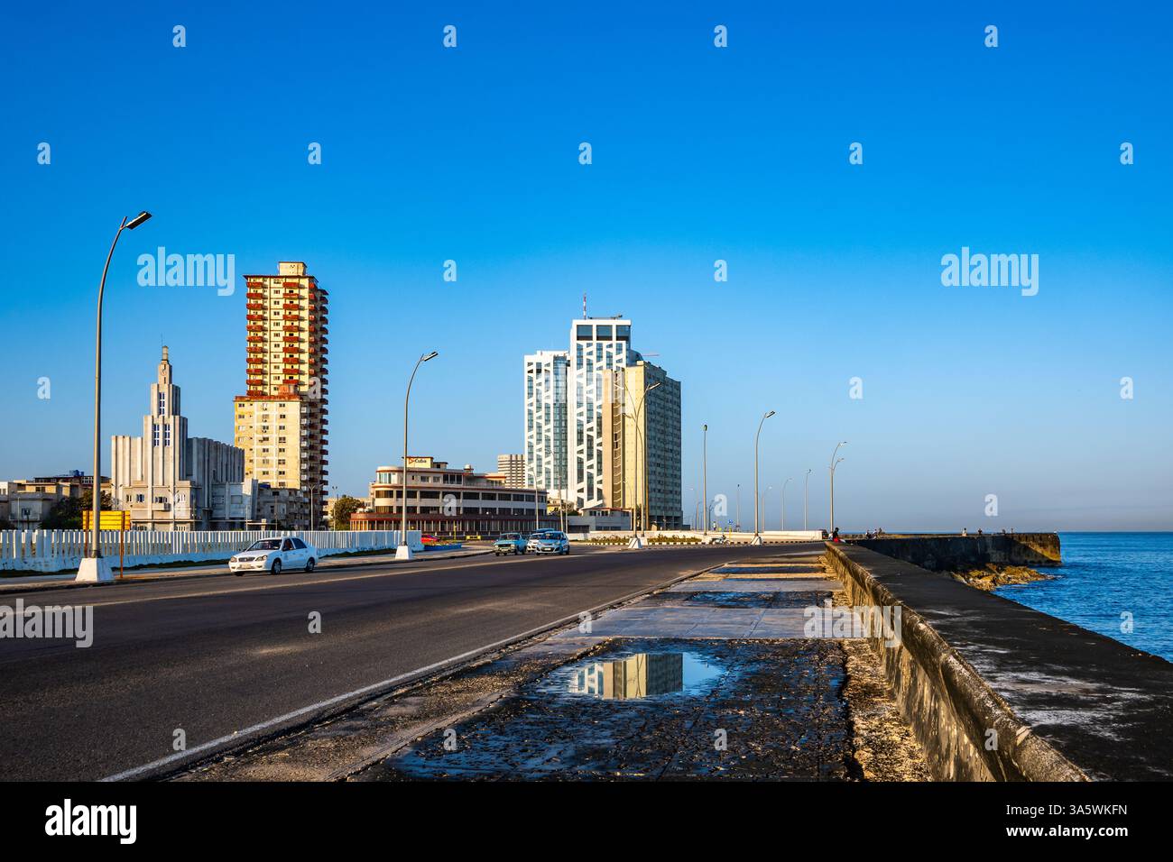 Breite Straße und Meeresmauer entlang der Malecón am Ufer. Havanna, Kuba. Stockfoto