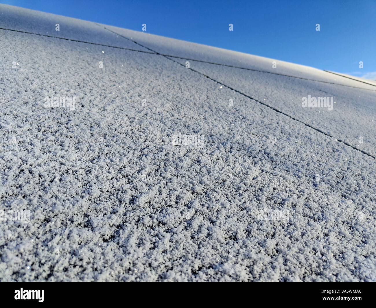 Frostbedecktes Dach unter klarem blauem Himmel im Winter. Stockfoto