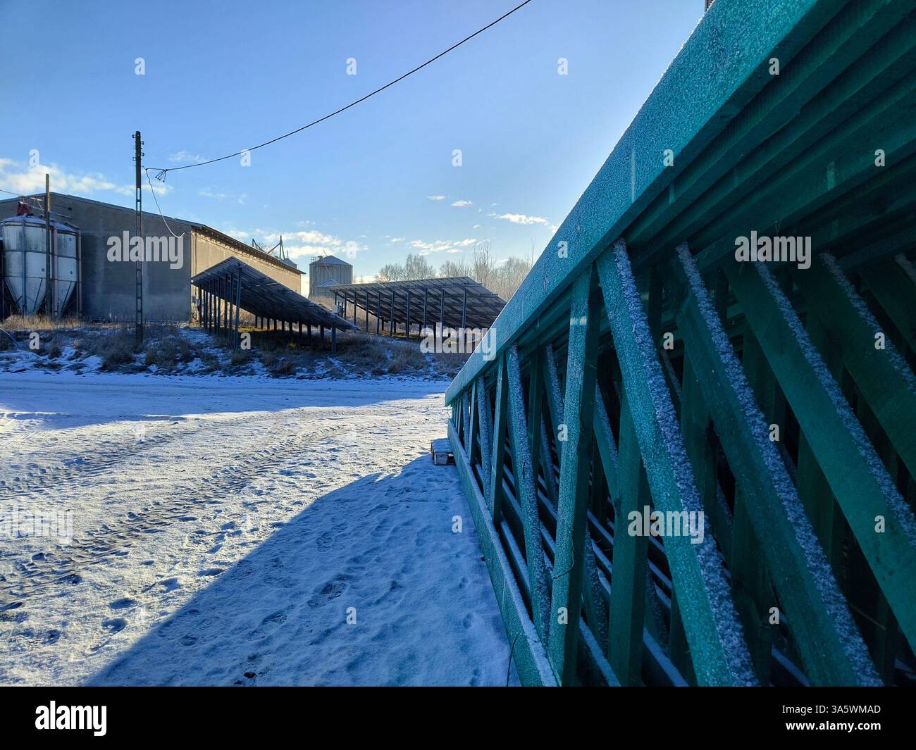 Frostige Industrieszene mit schneebedeckten Strukturen und klarem Himmel. Stockfoto