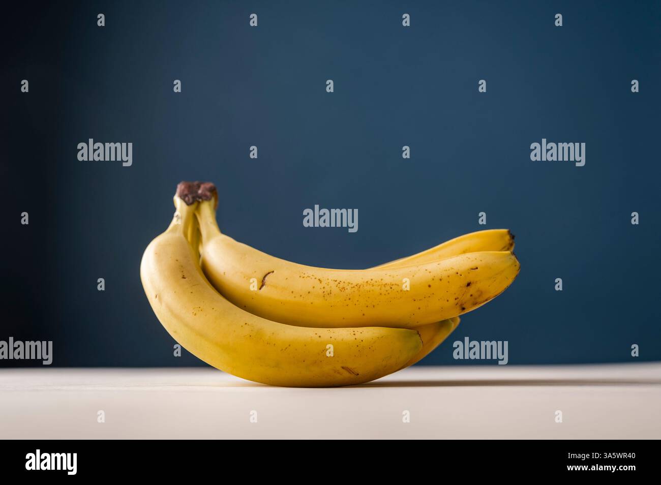 Studio-Aufnahme mit einem Haufen frischer reifer Bananen. Seitenansicht über blauem Hintergrund mit Kopierraum. Stockfoto