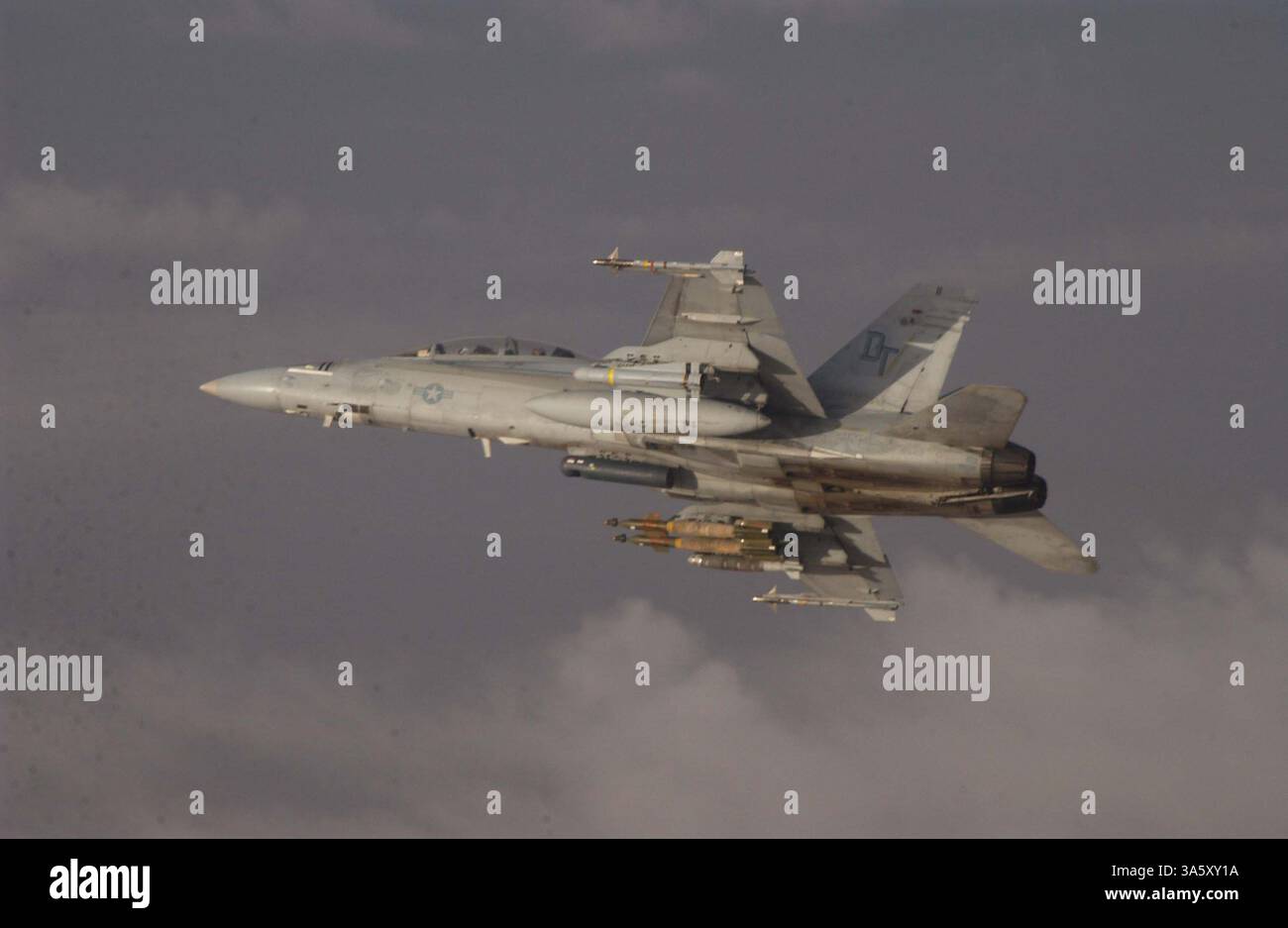 9. November 2004; Fallujah, Irak; eine F/A-18D Hornet mit Marine All Weather Fighter Attack Squadron 242 stürzt sich in die Wolken, nachdem sie am späten 9. November von einer KC-130 mit Marine Aerial Refueler Transport Squadron 452 in der Nähe von Fallujah, Irak, getankt hat. Die Hornet ist eines der Starrflügelflugzeuge der 3rd Marine Aircraft Wing, das Joint Direct Attack Munition wie zwei lasergeführte GBU-12 und eine GBU-38 unter dem rechten Flügel der Hornet einsetzt. Stockfoto