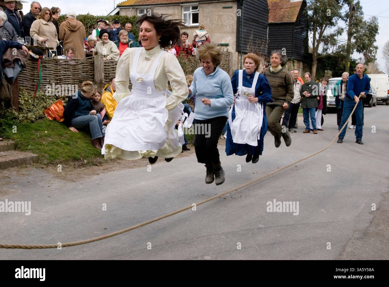 Überspringen Großbritannien, traditionelles jährliches Osterfest am Karfreitag, mehrere Frauen springen vor dem Rose Cottage Inn, Alciston, East Sussex, mit langen Seilspringen. England. 2006 2000er Jahre Großbritannien. HOMER SYKES Stockfoto