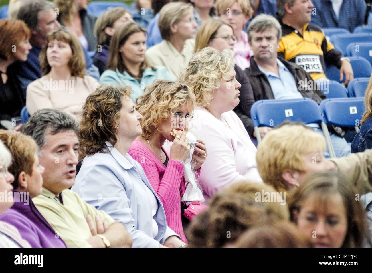 FAST FOOD, ROD STEWART CONCERT, 2002: Woman Eating Fast Food beim Rod Stewart Concert in Cardiff, Wales, Großbritannien im Juli 2002. Foto: Rob Watkins Stockfoto