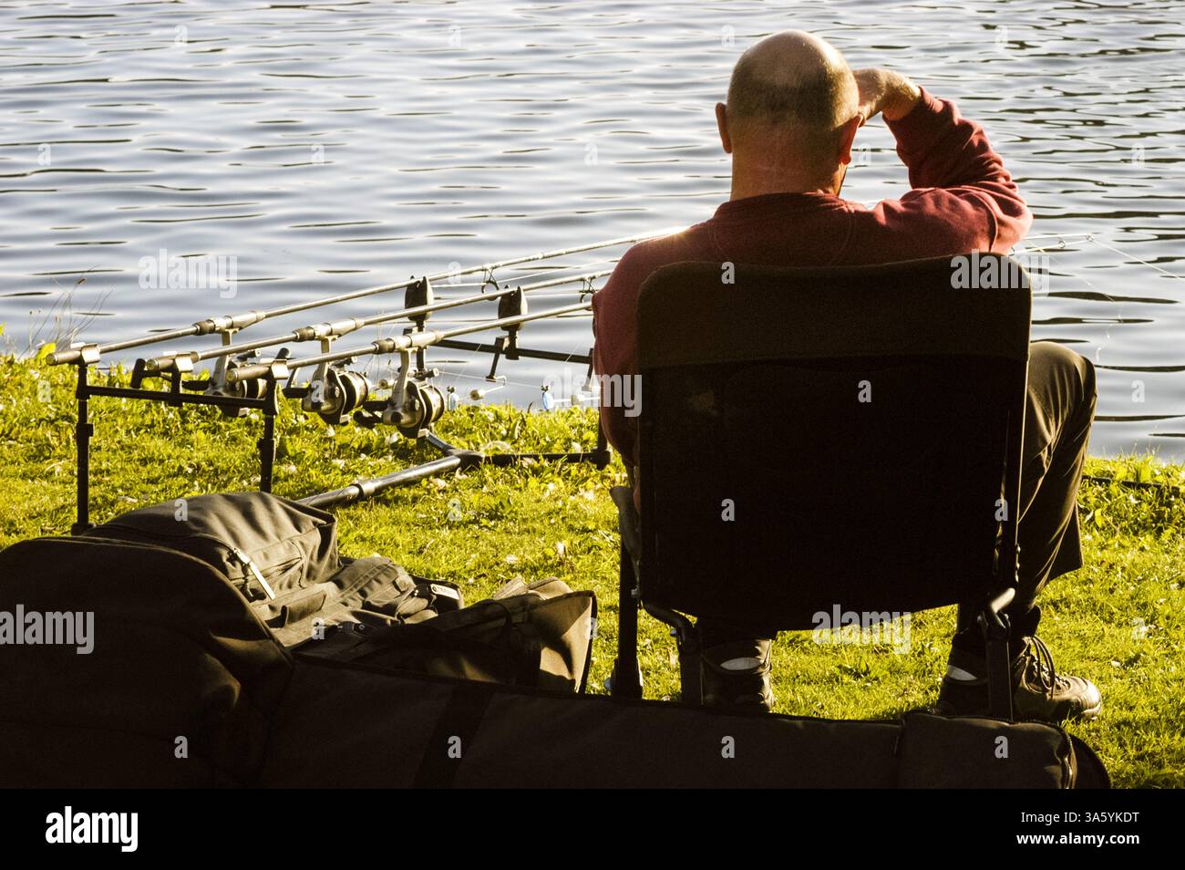 GOLFPLATZ ANGELN, ROATH PARK LAKE, SOMMERABEND, ENTSPANNUNG, ROATH PARK, CARDIFF, WALES, ARCHIV, 2002: ein Mann saß beim Angeln am Roath Park Lake mit mehreren Linien im Wasser. Im September 2002 entspannen sich Menschen im Roath Park, Cardiff, Wales, Großbritannien. Foto: Rob Watkins Stockfoto