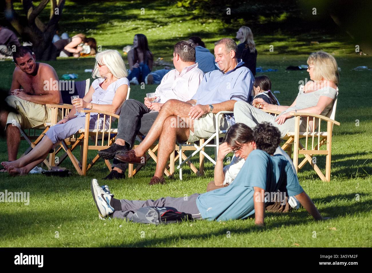 GEMISCHTE GENERATIONEN, GENIESSEN GEMEINSAM SONNENSCHEIN, BUTE PARK, CARDIFF, ARCHIV, 2002: entspannende Menschen im Cardiff Bute Park, Wales, Großbritannien. Foto: Rob Watkins Stockfoto
