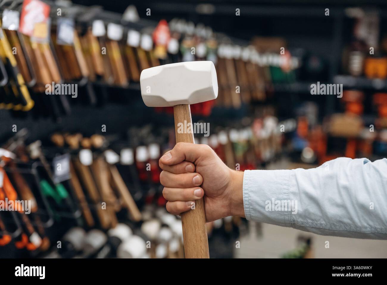 Haltehammer. Detaillierte Nahaufnahme der Hand des Mannes im Baumarkt. Stockfoto