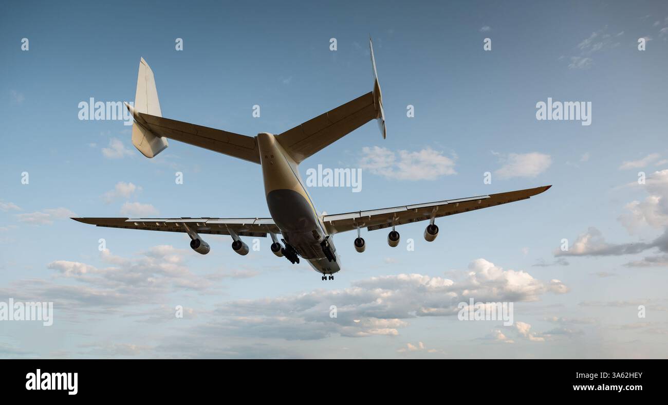 Frachtflugzeug an-225 bei finalem Anflug auf die Start- und Landebahn des Flughafens. Hinterer Dreiviertelblick des riesigen sechsmotorigen Mriya-Flugzeugs, Momente vor dem Aufsetzen. Stockfoto