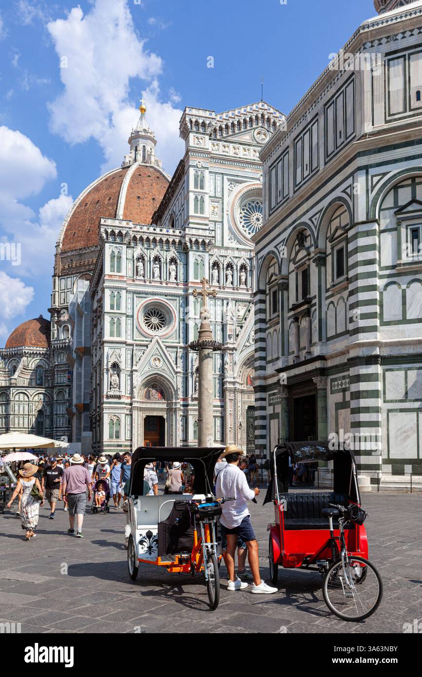 Vor der Kathedrale von Florenz (Il Duomo di Firenze oder Cattedrale di Santa Maria del Fiore) warten Fahrradtaxis auf Touristen. Stockfoto