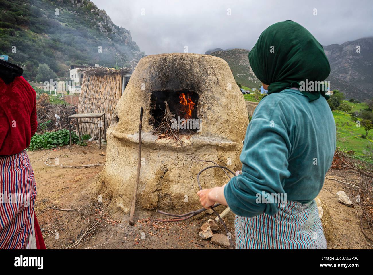 Berberfrauen backen im Ofen im Freien, Mezlafen Al Oued, Provinz Chefchaouen, Rif Mountains, Marokko, Nordafrika. Stockfoto
