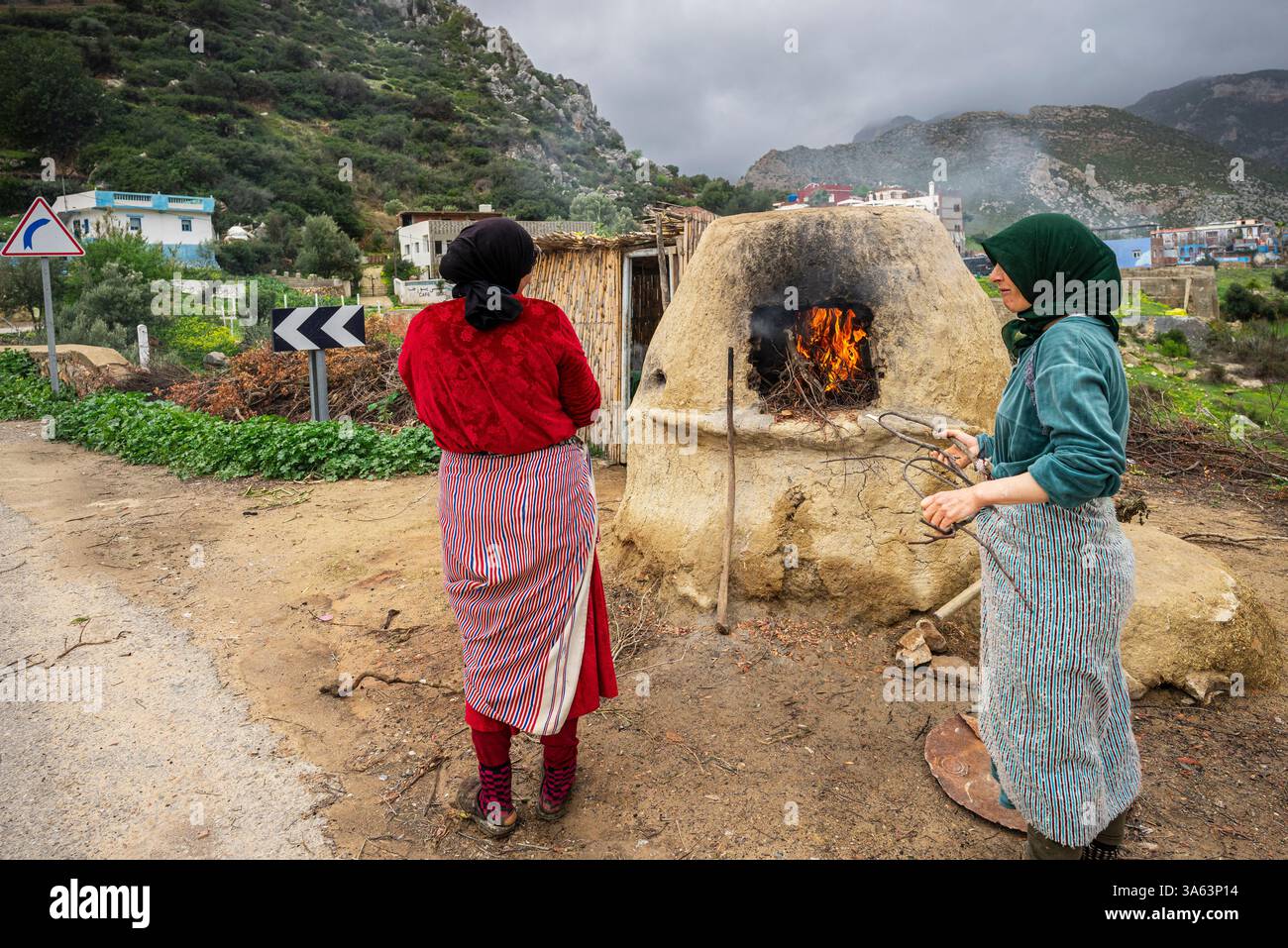 Berberfrauen backen im Ofen im Freien, Mezlafen Al Oued, Provinz Chefchaouen, Rif Mountains, Marokko, Nordafrika. Stockfoto