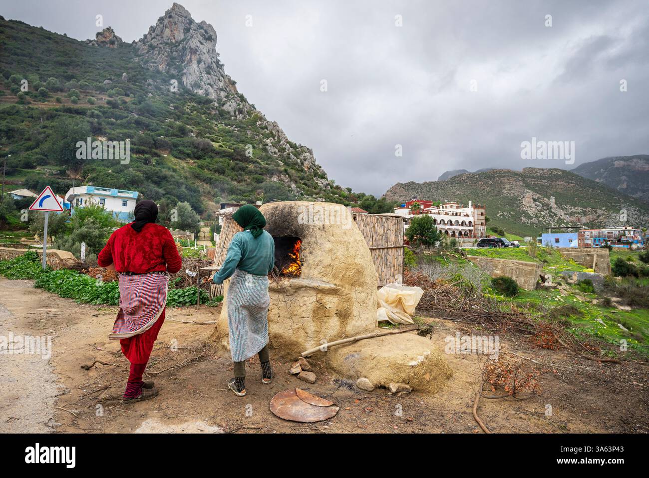 Berberfrauen backen im Ofen im Freien, Mezlafen Al Oued, Provinz Chefchaouen, Rif Mountains, Marokko, Nordafrika. Stockfoto