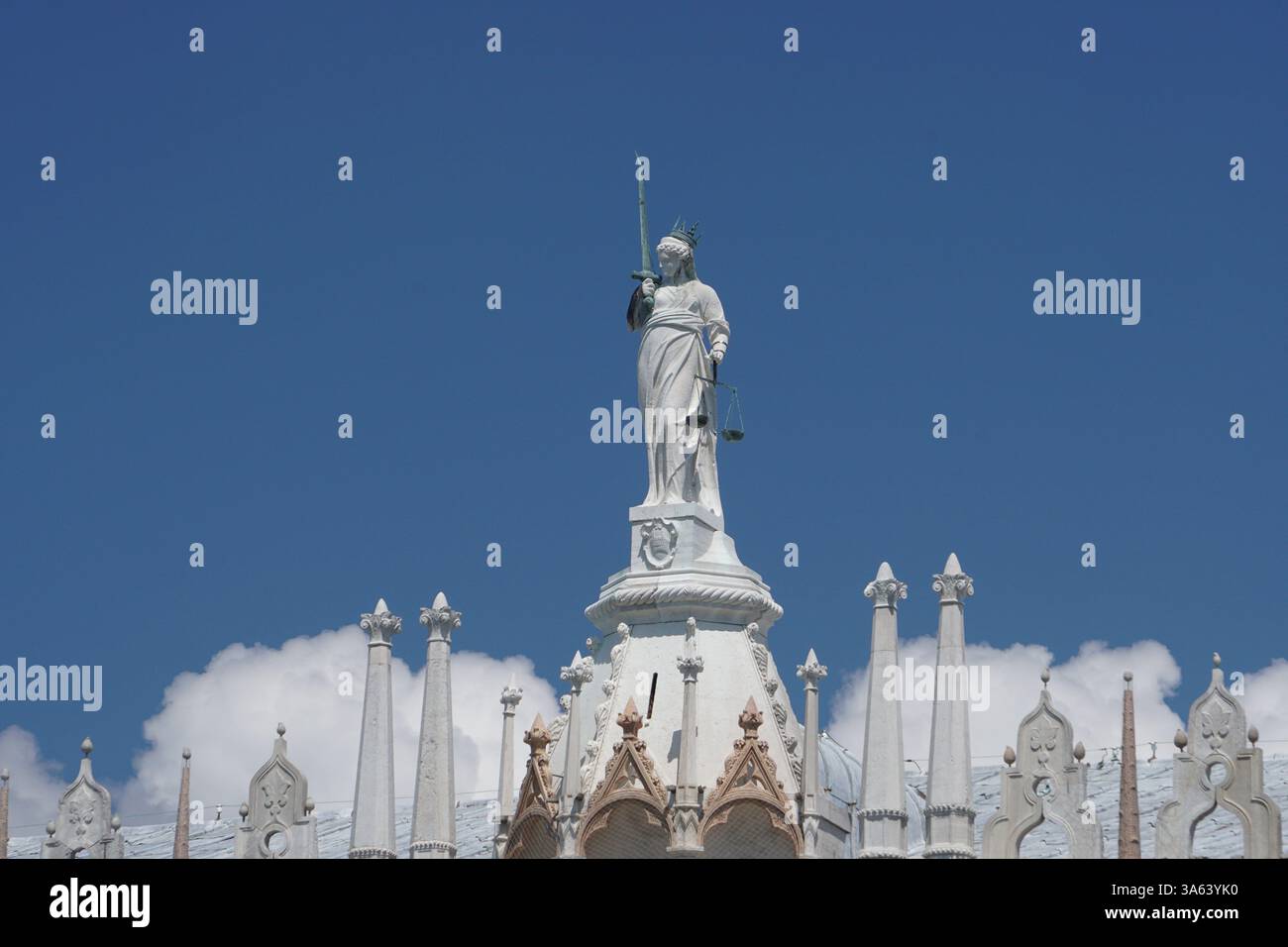 Eine Statue mit einem Schwert und der Waage der Gerechtigkeit auf dem Dach des Markusdaches in Benizia Stockfoto