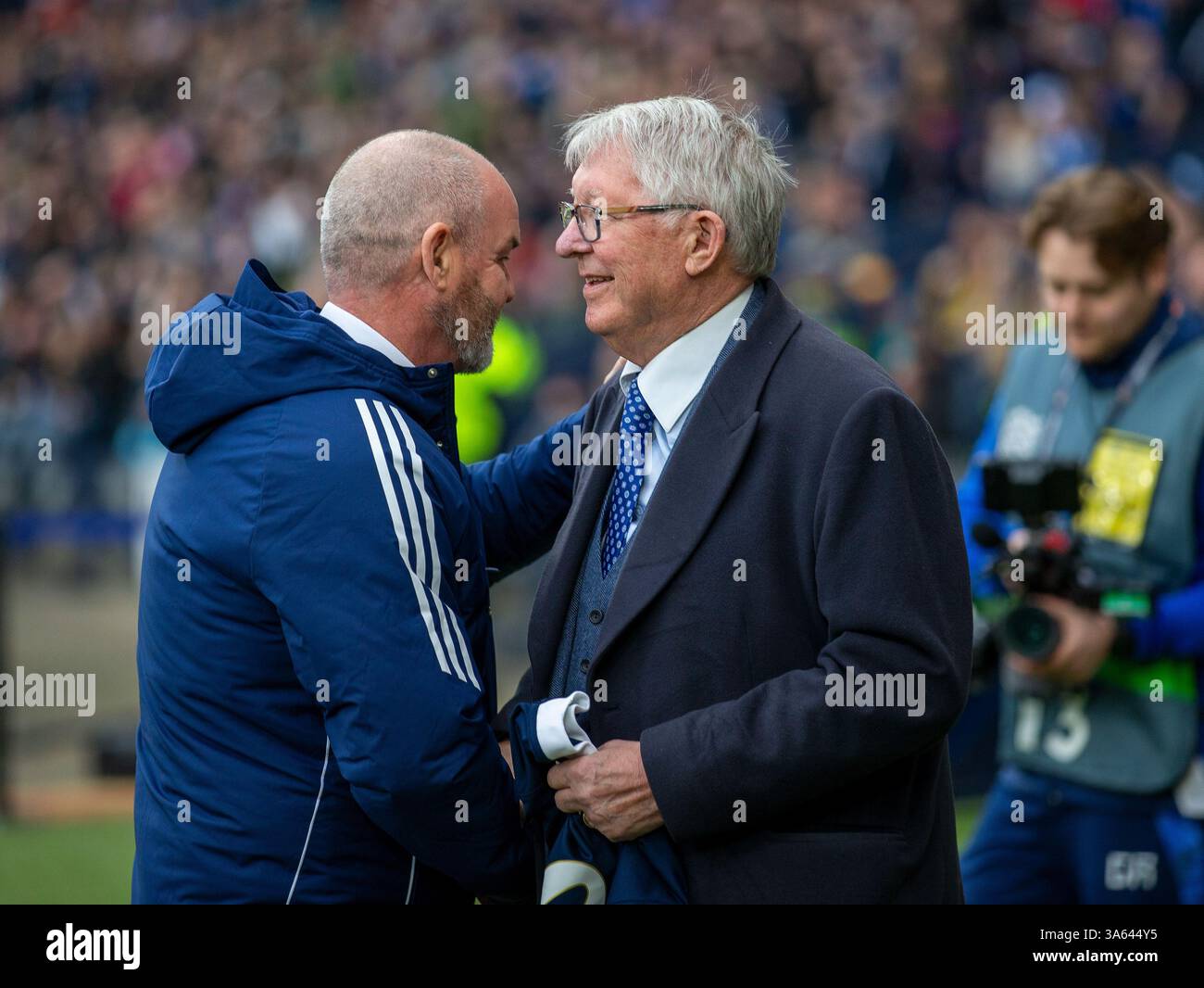 Hampden Park, Glasgow, Großbritannien. März 2025. UEFA Nations League Play offs International Football, Second Leg, Schottland gegen Griechenland; schottischer Trainer Stevie Clarke begrüßt Sir Alex Ferguson Credit: Action Plus Sports/Alamy Live News Stockfoto