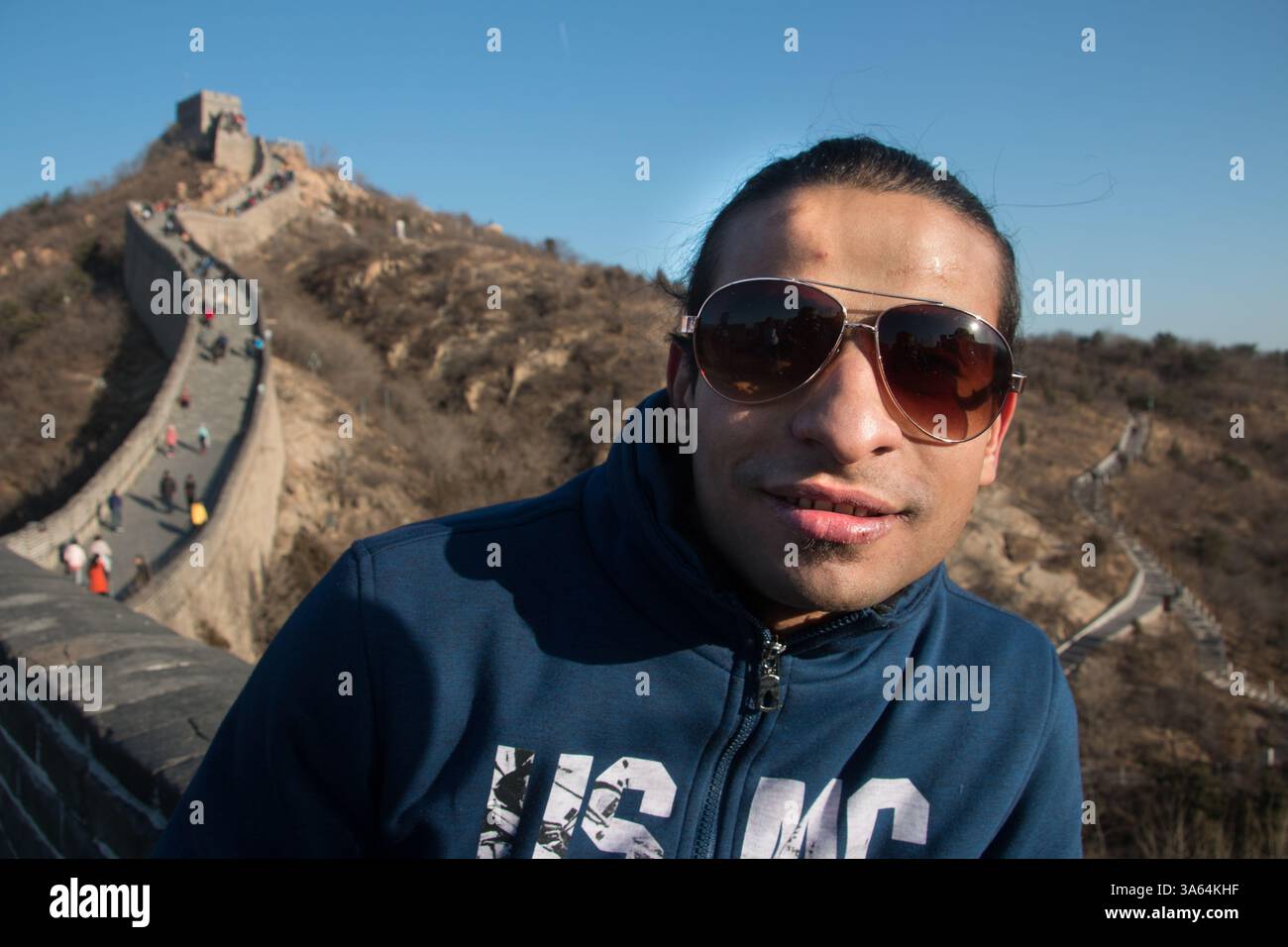 Der ägyptische Student Mahmoud posiert an der Wand. Auf einer zweitägigen Reise nach Peking halten die Studenten auf dem Weg zur Chinesischen Mauer in Badaling. A gr Stockfoto