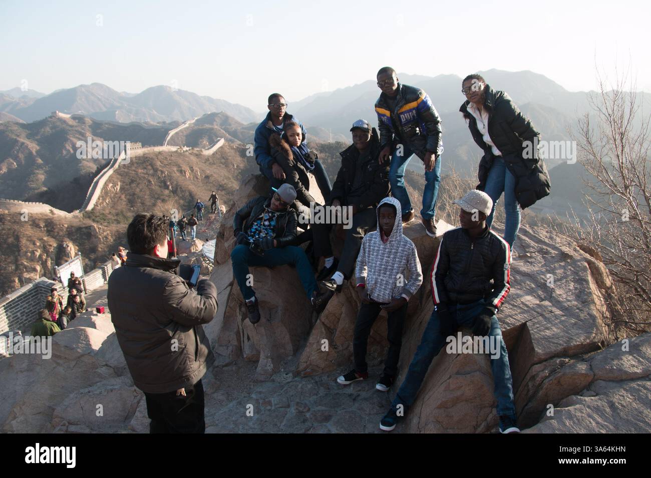 Die Schüler posieren für ein Gruppenbild an der Wand. Auf einer zweitägigen Reise nach Peking halten die Studenten auf dem Weg zur Chinesischen Mauer in Badaling. A Stockfoto