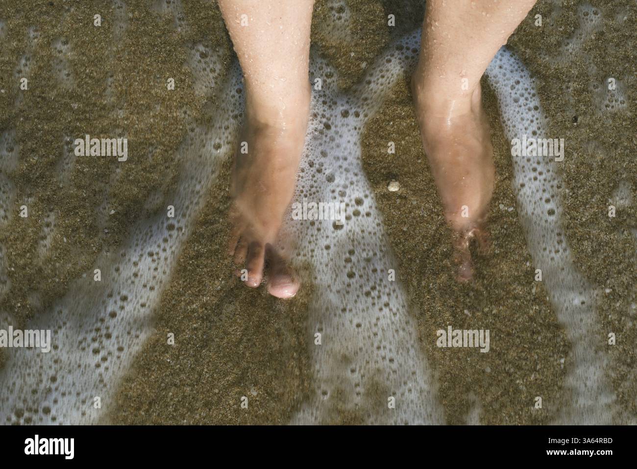 Zwei Beine in Wellen des Meeres. SUNY Tag Stockfoto