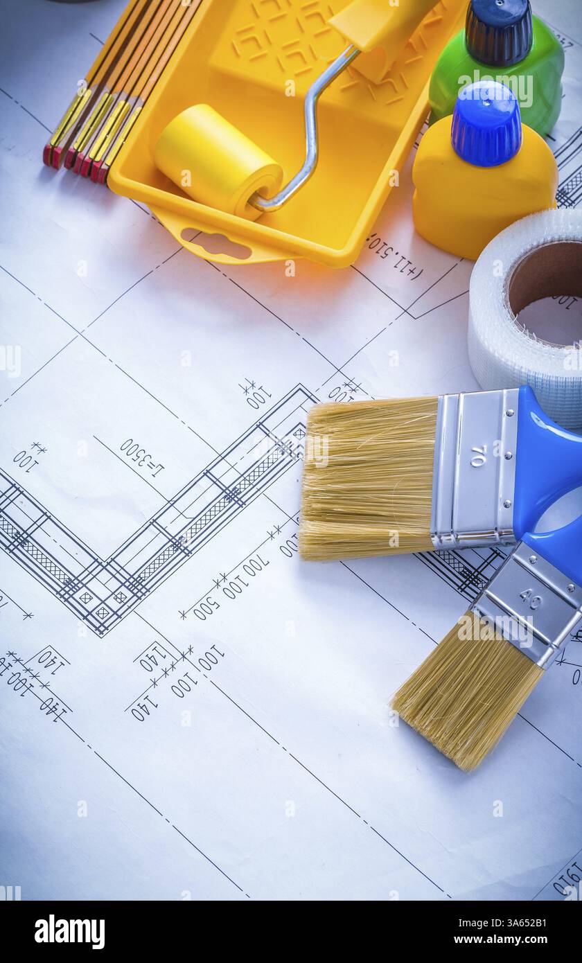 Bauplan mit Pinseln für Lackierwalzen, Kunststoffflaschen, Klebeband und Wartungskonzept für Holzzähler Stockfoto