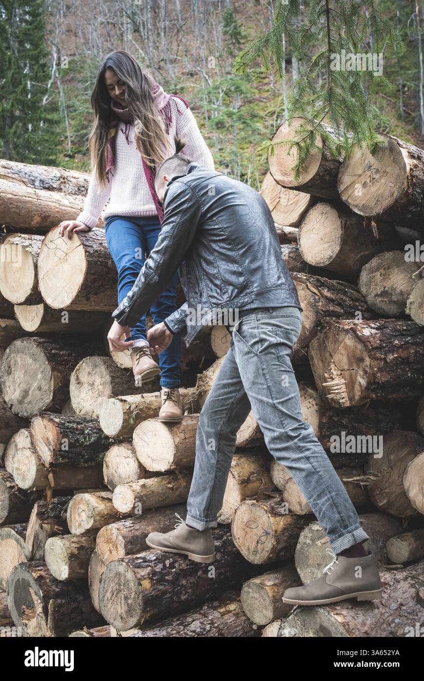 Junge Frauen und Männer auf Holz meldet sich im Wald Stockfoto