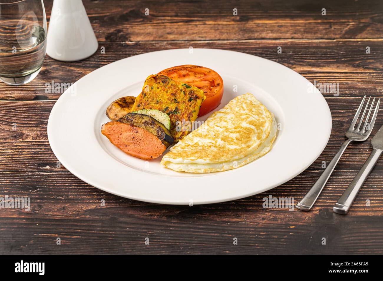 Rustikaler Frühstücksteller mit Spiegeleiern, gegrilltem Gemüse und putenspeck Stockfoto