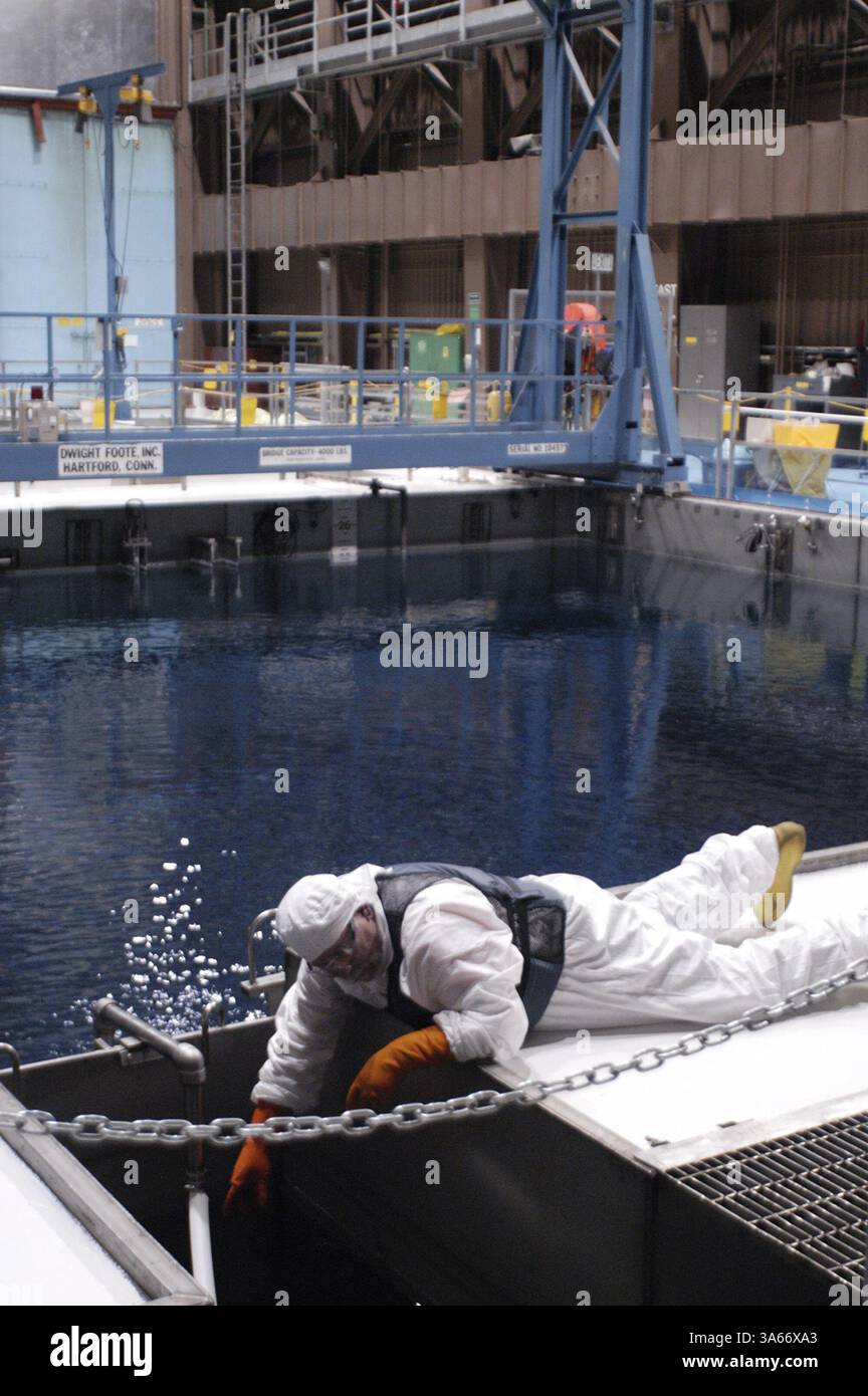 Mai 2004; Avila Beach, CA, USA; ! Ein Arbeiter, der Schutzkleidung trägt, einschließlich Handschuhen, um sich vor dem hochradioaktiven Wasser zu schützen, führt Wartungsarbeiten an einem der 440.000-Gallonen-Becken durch, in denen die abgebrannten Brennelemente des Kernreaktors aufbewahrt werden. Kritiker argumentieren, dass die abgebrannten Brennelemente ein ideales Ziel für Terroristen sind, die einen Angriff nutzen könnten, um das Becken zu entwässern und die abgebrannten Brennelemente zu entzünden, was zu einer langfristigen radioaktiven Kontamination der kalifornischen Zentralküste führt. Anlagenbetreiber sagen, dass die Tiefe der Pools zusammen mit der Stahl- und Betonauskleidung des Pools den Pool bildet Stockfoto