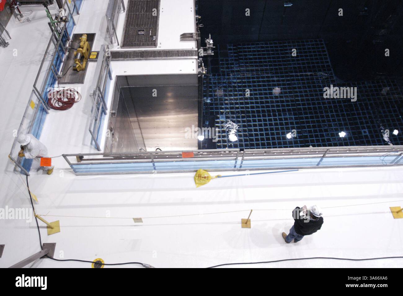 Mai 2004; Avila Beach, CA, USA; ! Ein Arbeiter in Schutzkleidung, links, betritt den hochradioaktiven Bereich, um Instandhaltungsarbeiten an einem der 440.000-Gallonen-Becken vorzubereiten, in denen die abgebrannten Brennelemente des Kernreaktors aufbewahrt werden. Kritiker argumentieren, dass die abgebrannten Brennelemente ein ideales Ziel für Terroristen sind, die einen Angriff nutzen könnten, um das Becken zu entwässern und die abgebrannten Brennelemente zu entzünden, was zu einer langfristigen radioaktiven Kontamination der kalifornischen Zentralküste führt. Anlagenbetreiber sagen, dass die Tiefe der Becken zusammen mit der Stahl- und Betonauskleidung des Beckens die Becken fast unbesiegbar macht Stockfoto