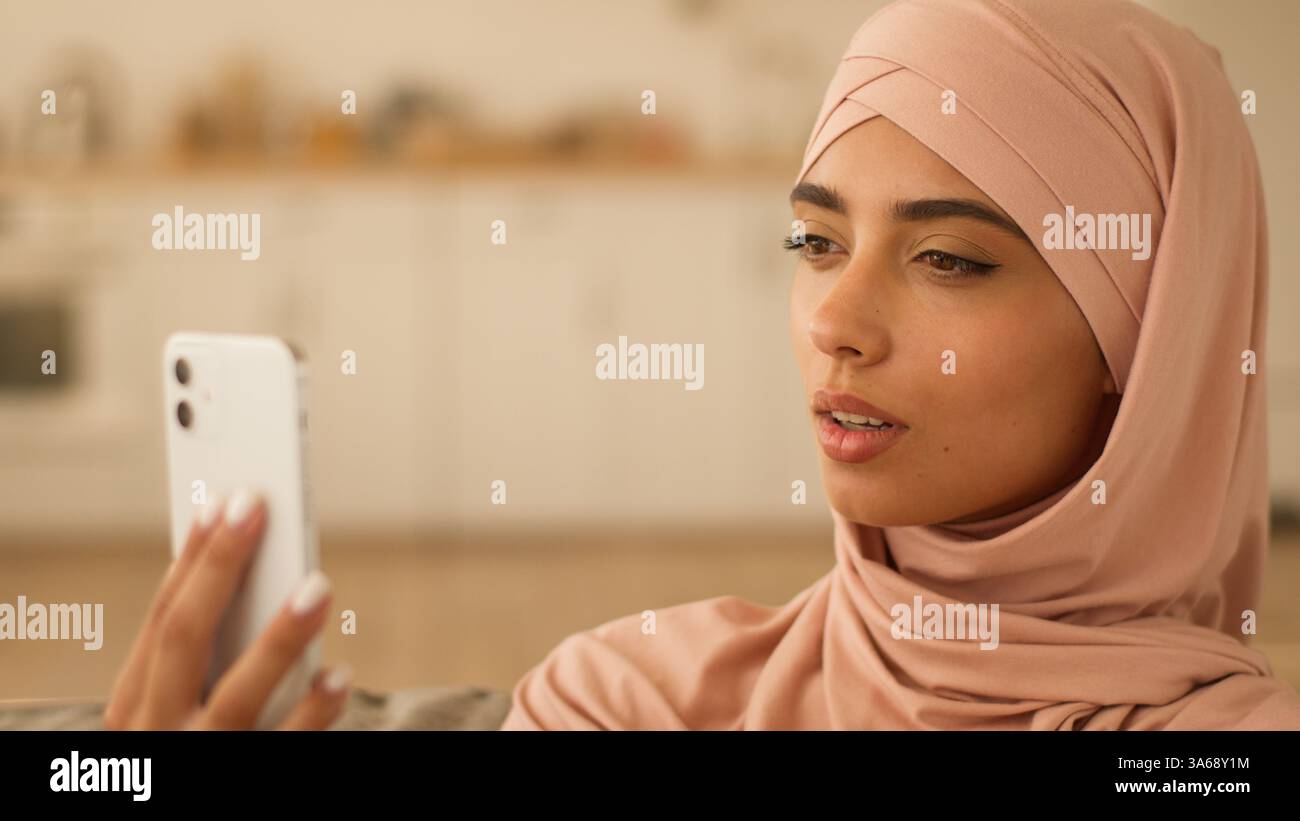 Arabische Frau Indisches muslimisches Mädchen weibliche Dame Religion im Hijab spricht Videoanruf Konferenzchat zu Hause, hält Handy-Gespräch mit Stockfoto