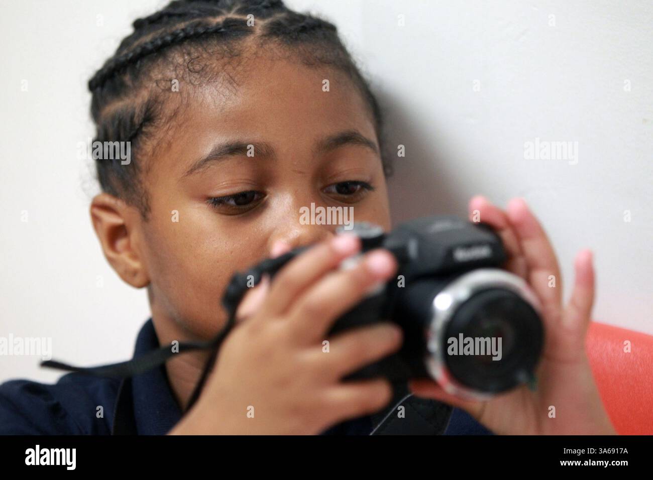 15. Oktober 2014 - Philadelphia, PA, USA - Asia Pagan, 6, schaut sich den LED-Bildschirm ihrer Kodak-Kamera an, während sie die Fotos ihrer Freunde Tae'Marr Tubbs und Logan Reed am 15. Oktober 2014 in Philadelphia betrachtet. Ein paar Kinder in einem der Obdachlosenheime der Stadt machten Fotos mit gespendeten Kameras - Bilder über ihr Leben, die als Bilder der Hoffnung bezeichnet wurden. Diese Schnappschüsse wurden nun in Karten umgewandelt, die als Spendenaktion für das Drueding Center, ein Obdachlosenheim, zur Verfügung stehen. (Bild: © Michael Bryant/TNS/ZUMA Wire) Stockfoto