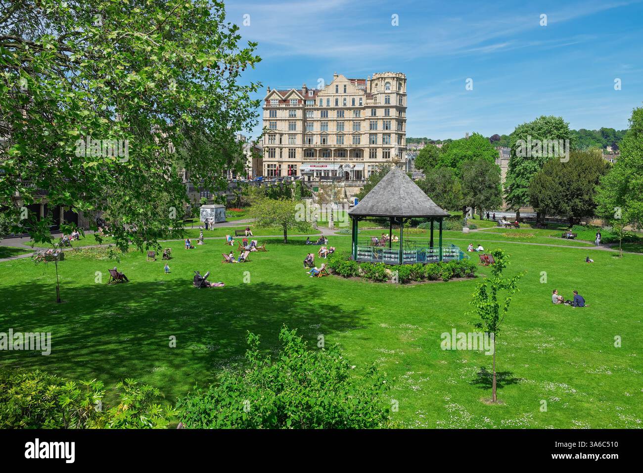 Leute, die warmes Wetter genießen, sitzen in Parade Gardens, Bath, Großbritannien. Der Park ist eine beliebte Touristenattraktion, ein Wahrzeichen neben dem Fluss Avon Stockfoto