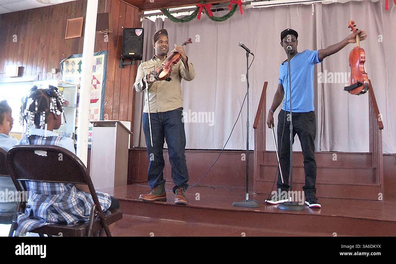 29. Januar 2015 - Tampa, Florida, USA - JAMES BORCHUCK | Staff. Kevin Kev Marcus Sylvester, links, zeigt seine Violine als Wilner will B Baptiste, rechts, zeigt Schüler seine Viola an der St. Peter Claver School in Tampa Donnerstag, 29. Januar 2015. Das Duo besteht aus der Gruppe Black Violin, die Hip-Hop und klassische Genres vereint und für alle gespielt hat, von den Truppen im Irak bis hin zu den beiden Eröffnungsbällen von Präsident Obama. Sie werden am 30. Januar um 19:30 Uhr in der Ferguson Hall des Straz Centers auftreten. (Foto: © James Borchuck/Tampa Bay Times/ZUMA Wire) Stockfoto
