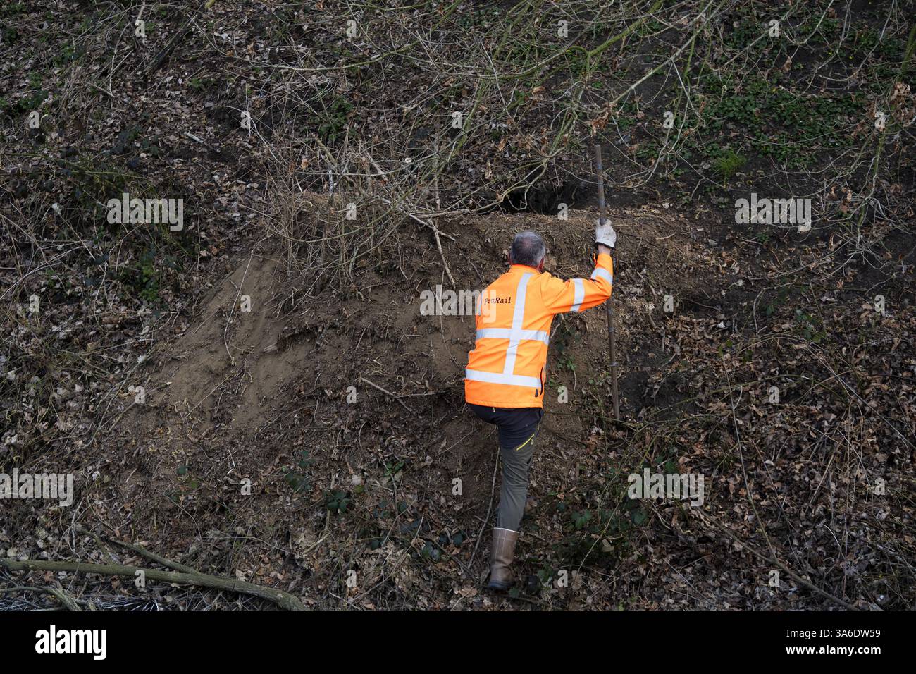 RAVENSTEIN - Ein Mitarbeiter von ProRail sucht nach Schäden, die durch Dachse entlang der Gleise in der Nähe des Maasdijk in Ravenstein verursacht wurden. ProRail hat in den letzten zwei Jahren Hunderte Dachsgleise entlang der Bahngleise entdeckt. Dazu gehören Kot und Grabketten. In etwa 10 Prozent der Fälle wird ProRail untersuchen, ob Maßnahmen in der Nähe der Gleise erforderlich sind. ANP JEROEN JUMELET niederlande Out - belgien Out Stockfoto
