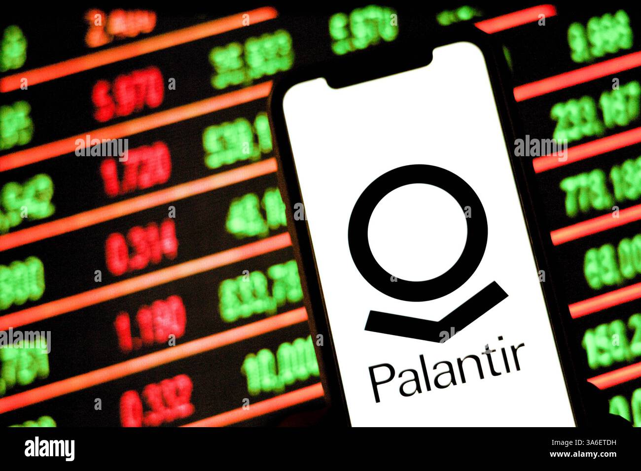 In dieser Fotoabbildung ist auf einem Smartphone ein Logo des Militärtechnologieunternehmens Palantir mit Börsennummern im Hintergrund zu sehen. Stockfoto