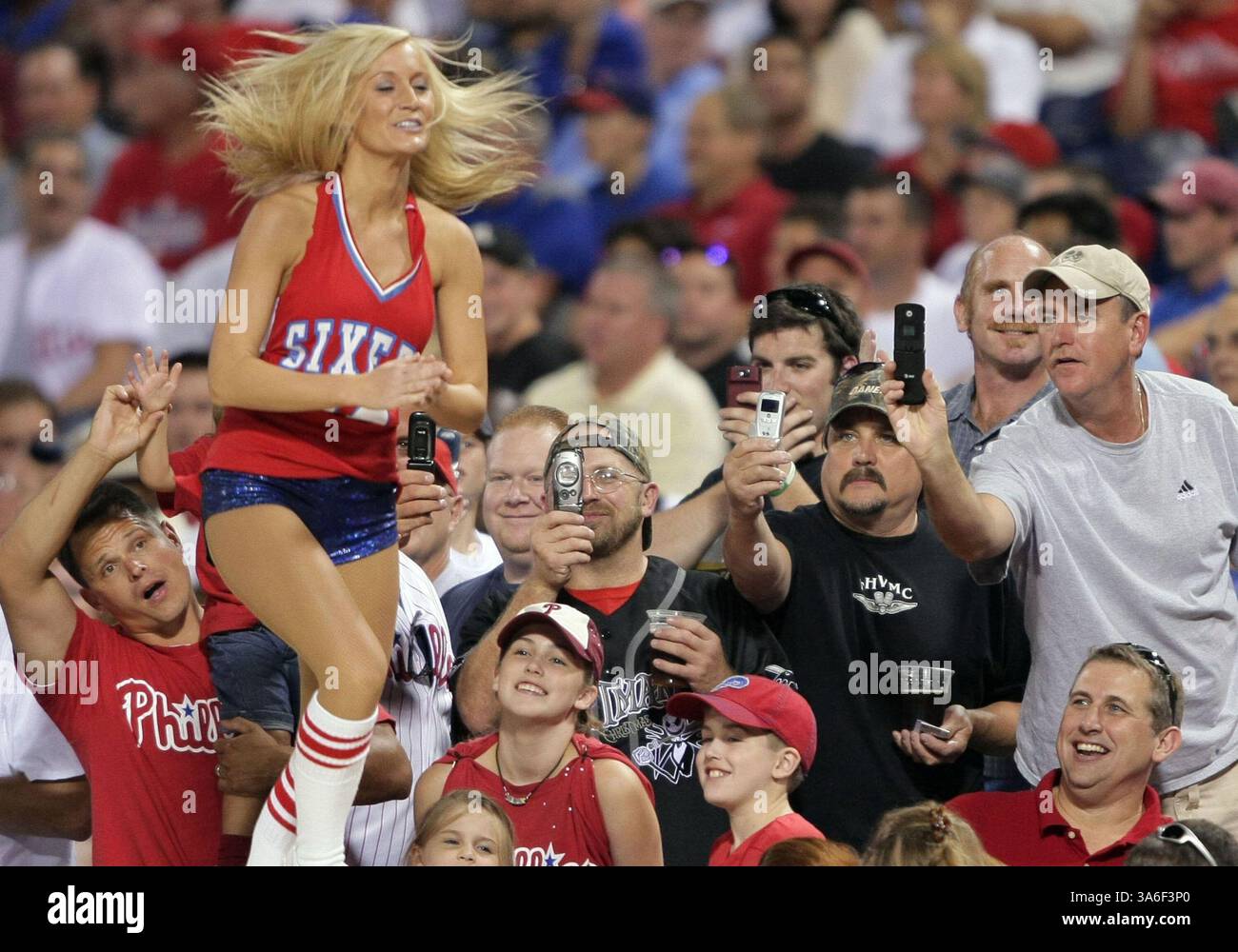21. August 2008 - Fans machen Fotos von einer Tänzerin der Philadelphia 76ers, die mit der Phanatic auf der Spitze des Phillies-Dugouts während der siebten Inning-Pause im Citizens Bank Park in Philadelphia, Pennsylvania, am Donnerstag, den 21. August 2008 auftritt. (Jerry Lodriguss/Philadelphia Inquirer/MCT) (Kreditbild: © Jerry Lodriguss/MCT/ZUMAPRESS.com) Stockfoto