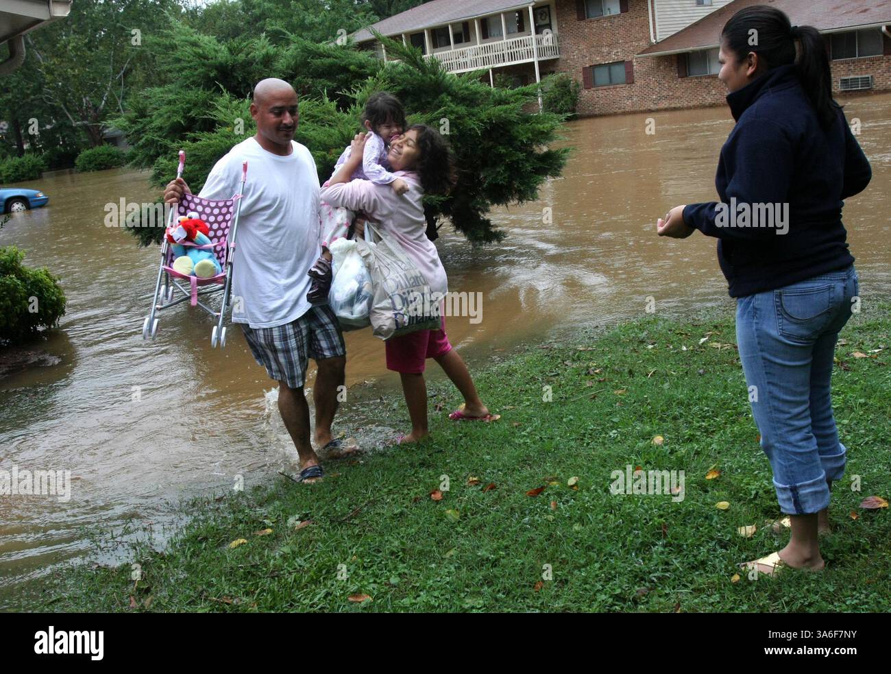 6. September 2008 - Ena Barahona aus Raleigh, rechts, und Crystal Gonzalez, 9, holen die zweijährige Angelina Baladez von Barahonas Ex-Ehemann Gabriel Baladez ab, der im Camelot Village lebt, einem der Chapel-Hill Apartments, die überschwemmt wurden, nachdem der Tropensturm Hanna am Samstag, den 6. September 2008 schwere Regenfälle in die Gegend gebracht hatte. (Takaaki Iwabu/Raleigh News & Observer/MCT) (Bild: © Takaaki Iwabu/MCT/ZUMAPRESS.com) Stockfoto